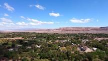 Aerial shot drone flies to right over green space in middle of Atacama desert