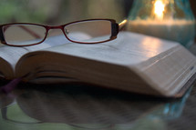 reading glasses lying on an open Bible 
