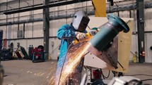 Welder using a grinder tool on industrial pipe 1