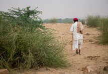 Man walking on a dirt road.