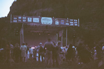 crowds around a stage at an outdoor music festival 