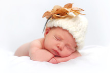 sleeping infant girl with wool hat and flower