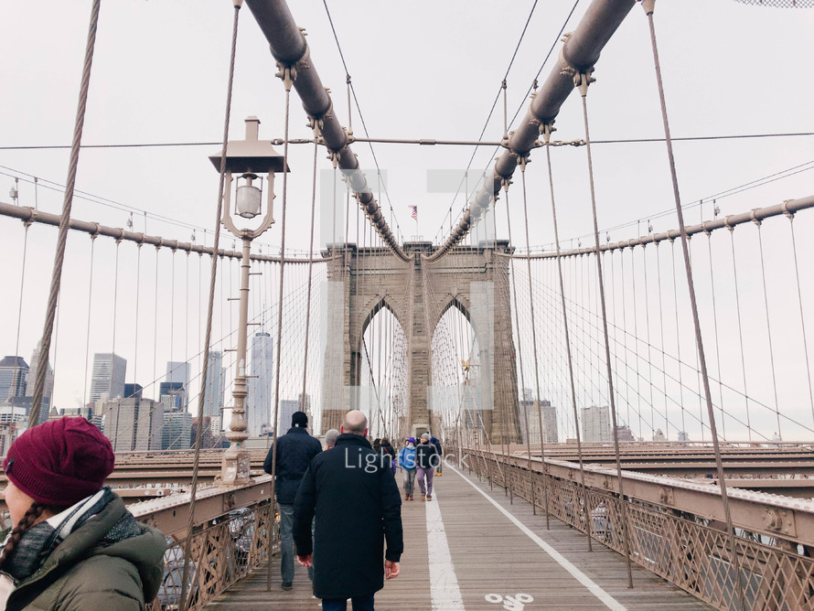 people walking across the Brooklyn Bridge 