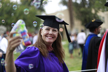 a graduate blowing bubbles 