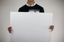 a man holding a blank poster board 