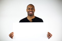 man holding a blank poster board 