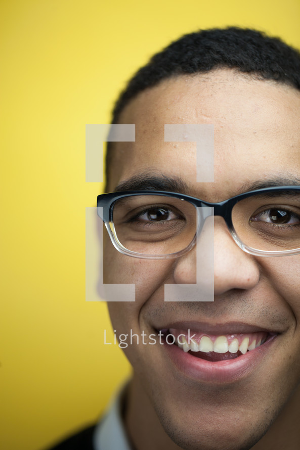 face of a smiling man in reading glasses 