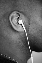 a man's ear with earbuds 