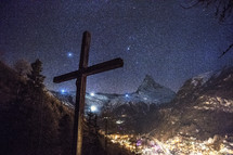 cross in a valley at night with snow 