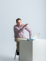 a man sitting at a desk talking 