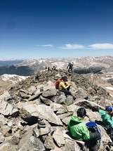 hikers resting on a mountaintop 