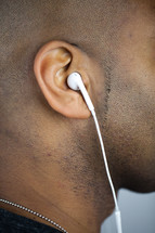 ear of a man with earbuds 