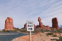 red rock cliffs and one way sign 