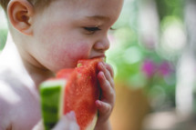 toddler eating a slice of watermelon