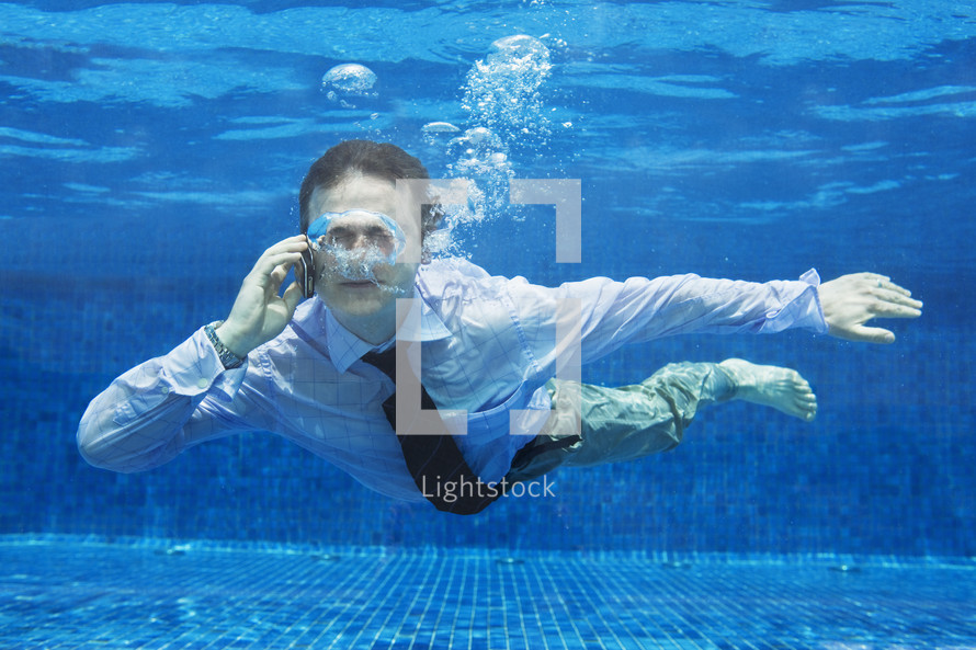 Businessman on the phone underwater