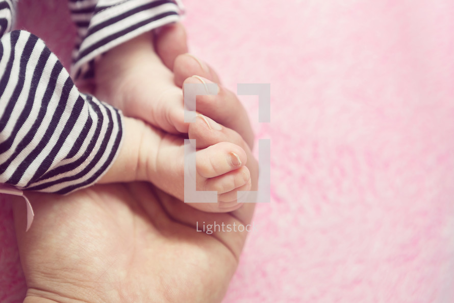 newborn feet in cupped hands 