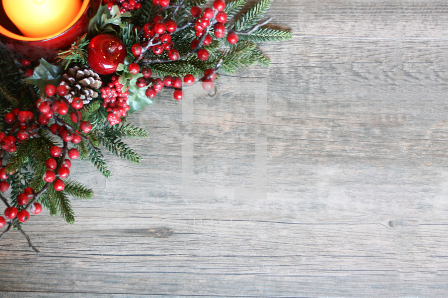 red berries and Christmas greenery on a wood background 