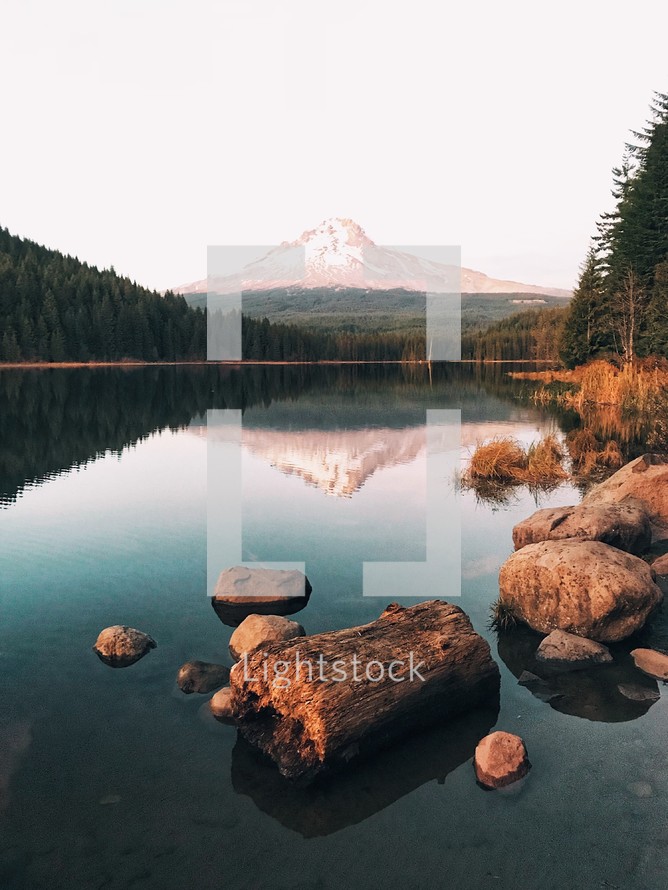 reflection of a mountain peak on calm lake water 