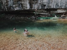 father and son swimming in a waterhole 