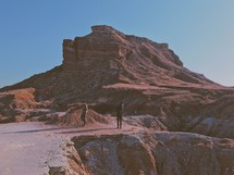 men exploring rock formations in a desert 