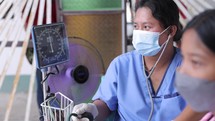 Asian Nurse Using Blood Pressure Machine