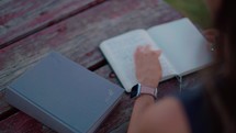 Woman Reading Bible and Journaling Outside at Sunset