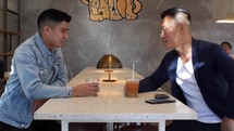 two guys talking over coffee 