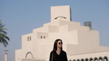 Tourist woman walking at MIA park with Islamic museum behind
