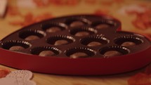 A heart shaped box of chocolates being set down and opened