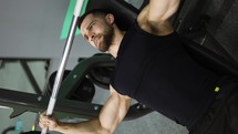 Men working out barbell bench press in the gym.