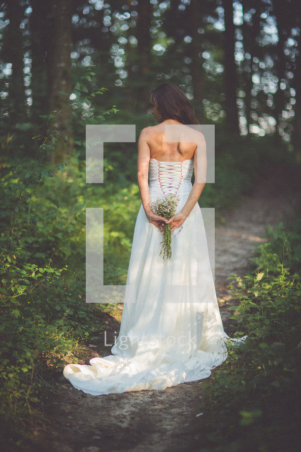 bride holding a bouquet behind her back 