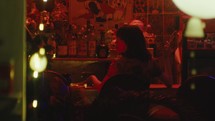 Girl looking at someone in a bar with red light