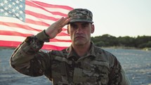 United States Marines military stand with salute against american flag on the beach