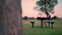 Woman Reading Bible and Journaling Outside at Sunset