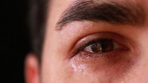 Close up of an young man eye crying