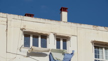 Laundry hanging in the midday sun against a white wall in Spain