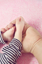 cupped hands holding newborn feet 