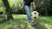 man kicking a soccer ball 