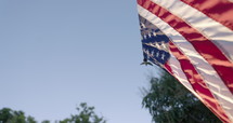American flag hanging in front of house - close up against blue sky