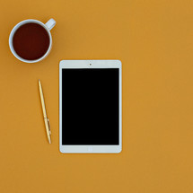 tablet, pen, and coffee cup 