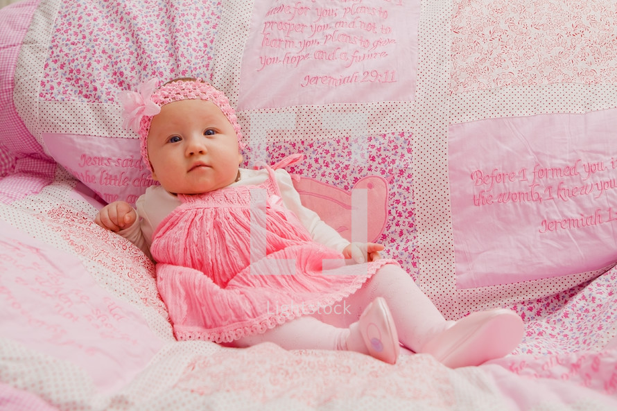 baby girl on pink blanket