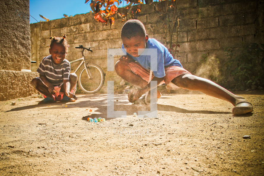 Haitian orphan plays marbles