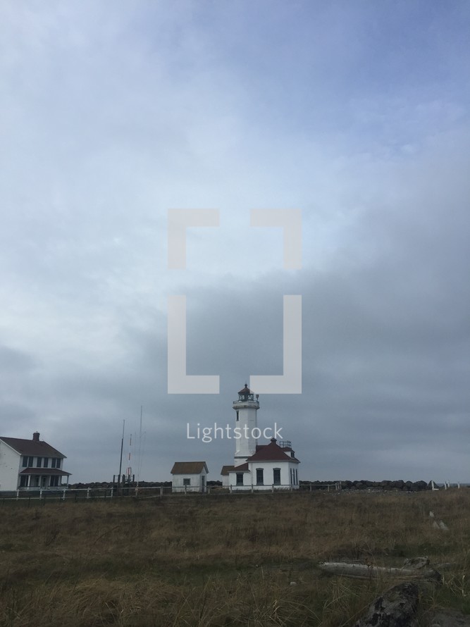 a lighthouse and lighthouse building on a coast 