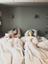 father and son reading in bed