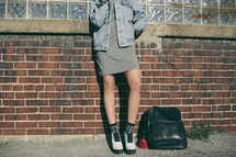 teen girl standing near a backpack 