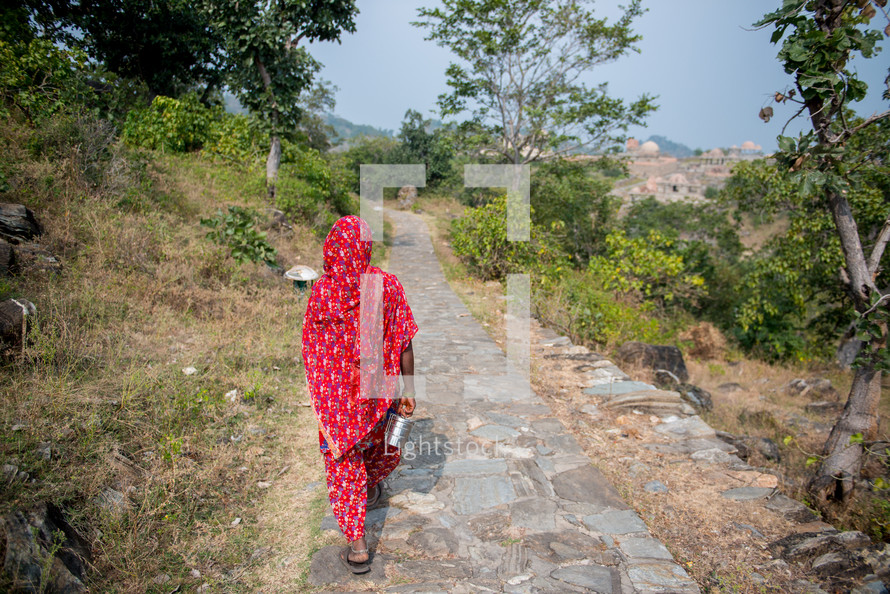 a woman walking on a sidewalk in India 