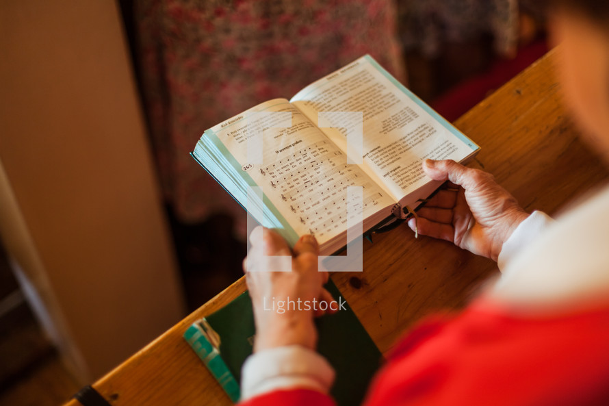 elderly woman holding a hymnal 