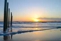 Posts on a beach at sunrise