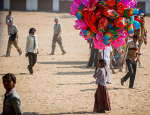 a girl selling balloons at a festival in India 