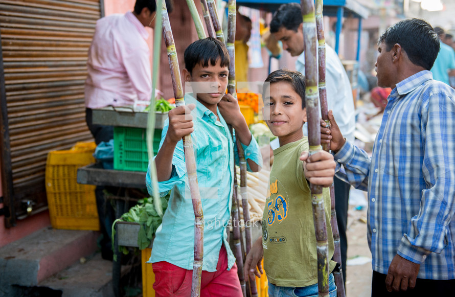 children with bamboo sticks at a market in Mandawa, India 